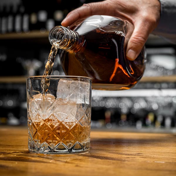 dark alcohol being poured into glass